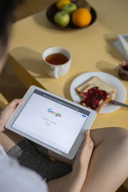 Des mains utilisant un smartphone à côté d'un ordinateur portable avec des graphiques boursiers, illustrant le trading numérique.